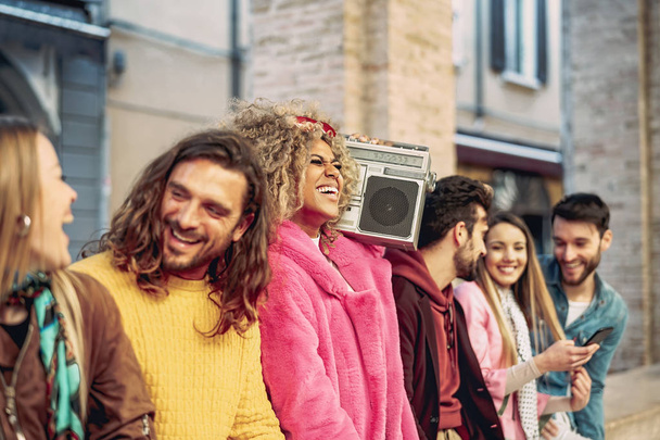 Freundeskreis mit Spaß Musik hören mit Vintage-Boombox - fröhliche junge Leute machen Party im Freien - Jugendkultur und Millennial-Lifestyle-Konzept - Foto, Bild