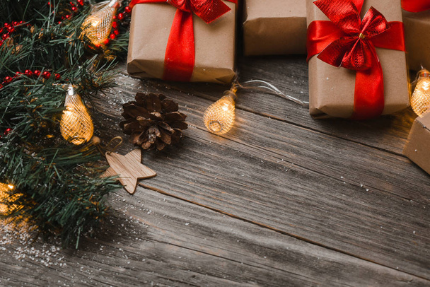 Χριστουγεννιάτικα κουτιά δώρων σε ξύλινη επιφάνεια με φώτα - Φωτογραφία, εικόνα