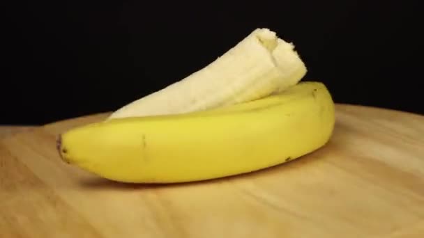 dos plátanos uno entero y uno sin cáscara giran 360 grados
 - Metraje, vídeo