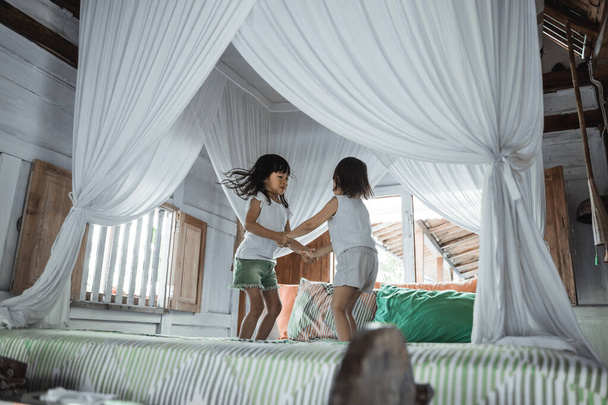 Two little girls jumping on bed - Foto, Imagem