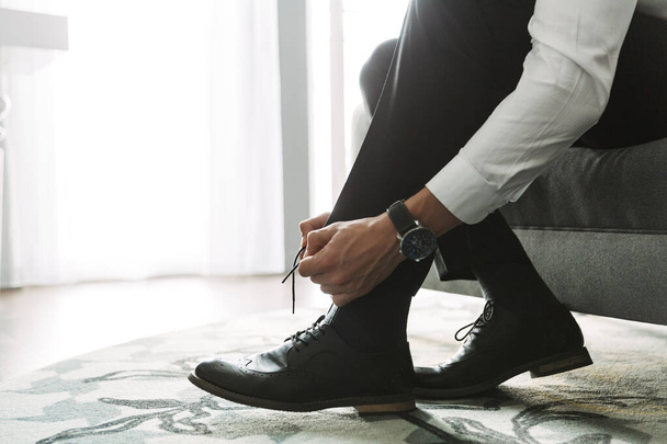 Cropped image closeup of businesslike man tying his shoe laces w - Fotó, kép