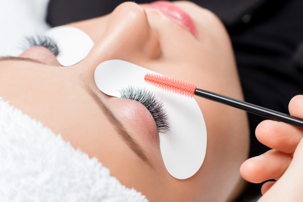 Macro photo woman with long lashes in beauty salon. Concept eyelash extension procedure - Photo, Image