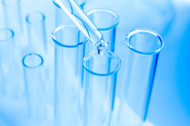 Pipettentropfer und Reagenzglas auf blauem Hintergrund Wissenschaft - Foto, Bild