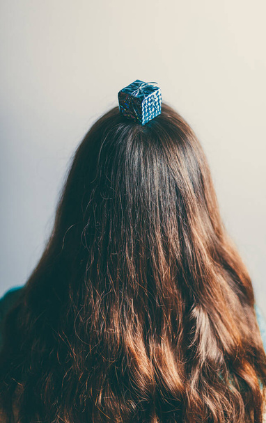 Beautiful Christmas toys on the head of a girl with long hair - Foto, Imagen
