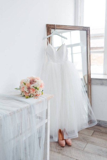 Scenery for the morning of the bride with a white wedding dress and a bouquet. - Photo, image