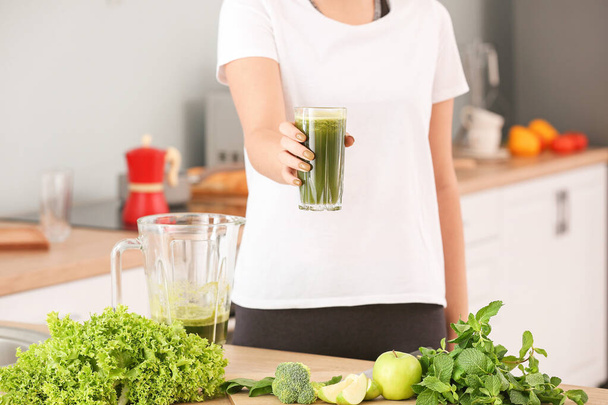 Woman with glass of healthy smoothie in kitchen - Fotoğraf, Görsel