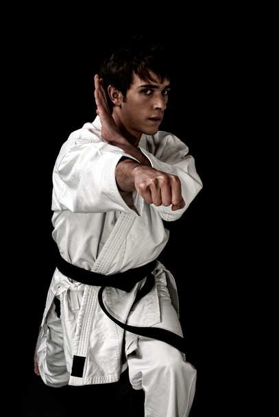 Contrast karate young fighter on black - Photo, Image