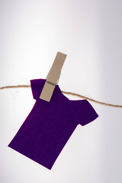 Des vêtements en papier accrochés à une corde avec des pinces à linge
 - Photo, image
