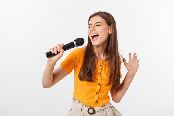 Nuori kaunis nainen onnellinen ja motivoitunut, laulaa laulun mikrofonilla, esittää tapahtuman tai pitää juhlat, nauttia hetkestä
 - Valokuva, kuva