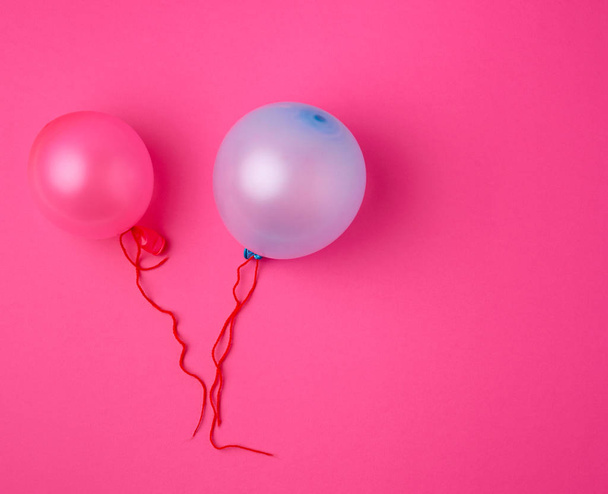 inflated blue and pink rubber balloons on a pink background - Фото, изображение