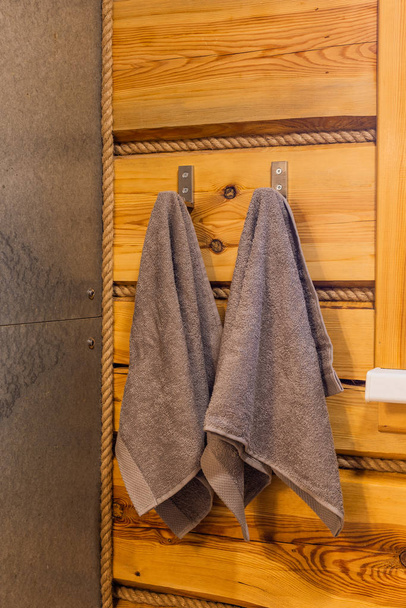 zwei Handtücher hängen an einer Holzwand in der Badewanne. - Foto, Bild