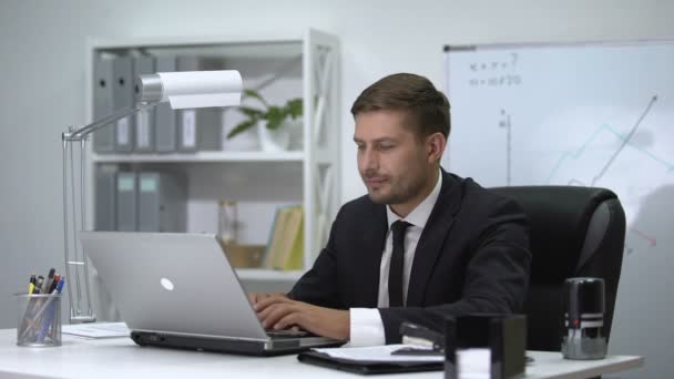 Male boss finishing work on laptop, standing up and feeling strong pain in back - Séquence, vidéo