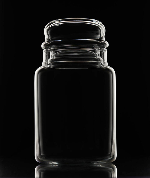 Білий силует порожньої скляної банки на чорному тлі
 - Фото, зображення