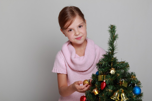 Smiling girl near a Christmas tree - Fotoğraf, Görsel
