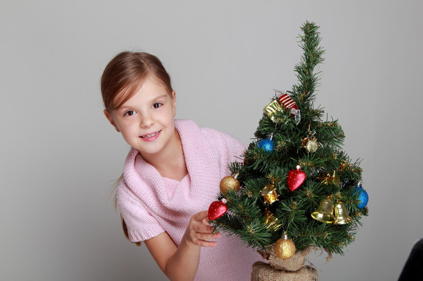 Child near a decorated Christmas tree - Fotó, kép