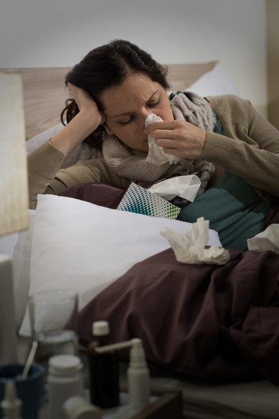 ベッドの中でくしゃみのインフルエンザと病気の女性 - 写真・画像