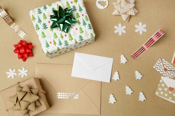 Emballage cadeau de Noël sur la table, directement au-dessus de la vue sur papier d'emballage, arcs et rubans, articles décoratifs pour l'emballage des boîtes-cadeaux
 - Photo, image