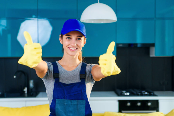 Housewife in pink gloves holds window cleaner and shows ok sign - Fotó, kép