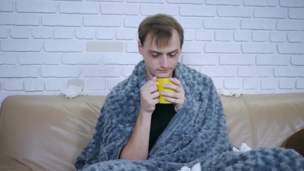 malade bel homme avec rhumes et boissons thé chaud avec citron assis sur le canapé à la maison en hiver. Grippe malade adulte rhume personne maladie virus portrait ralenti pilules
 - Séquence, vidéo