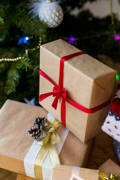 Gift boxes with ribbons with christmas tree at background - Photo, Image
