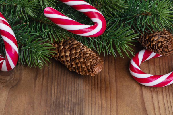 Christmas tree branch decorated with garlands, cones and caramel - 写真・画像