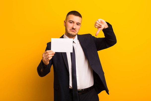 young handsome businessman  against flat background with a placard - Photo, image