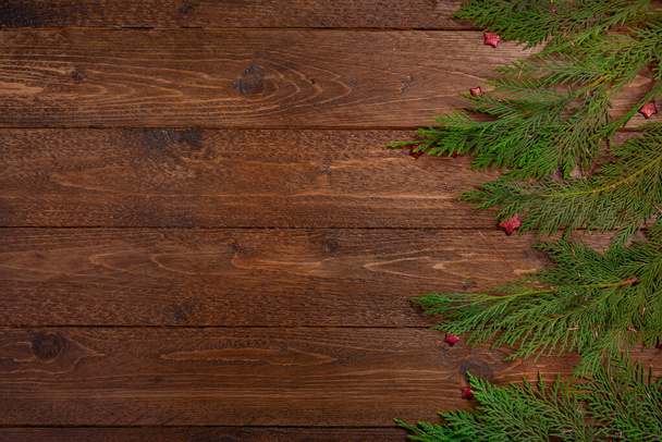 Vánoční kompozice. Cypřišové větve a malé červené hvězdy, na tmavém dřevěném pozadí. Vánoce, zimní koncept. Byt ležel, horní pohled. - Fotografie, Obrázek
