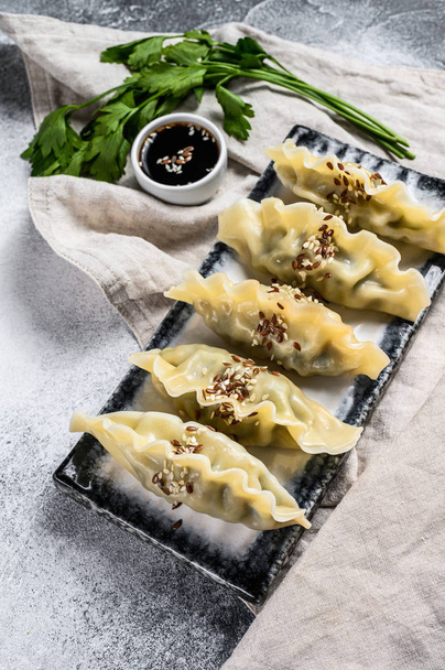 Steam Korean dumplings on a ceramic plate. Gray background. Top view - Фото, зображення