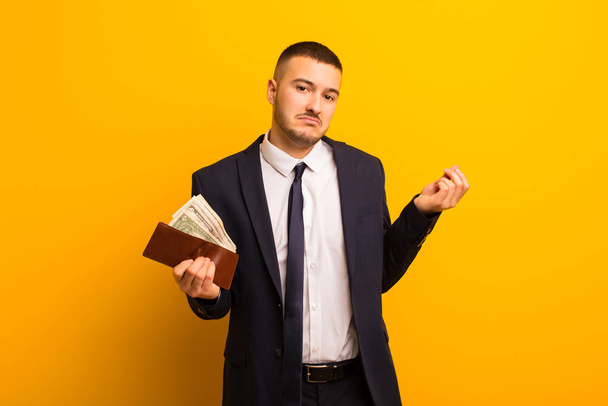 young handsome businessman  against flat background money concept - Foto, afbeelding