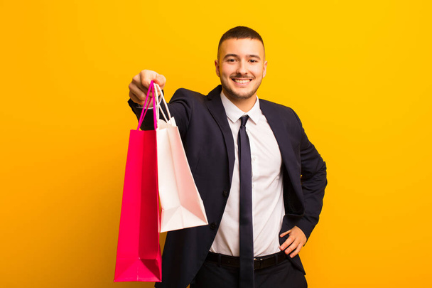 young handsome businessman  against flat background with shopping bags - Foto, Bild
