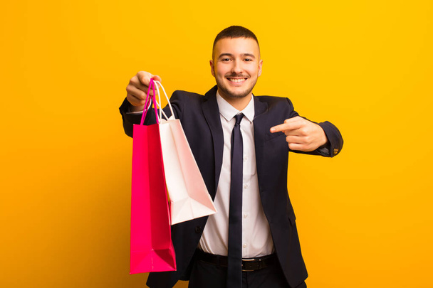 young handsome businessman  against flat background with shopping bags - Photo, Image