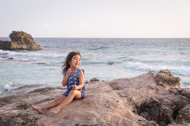 Fille de trois ans sur un rocher dans la mer des Caraïbes
 - Photo, image