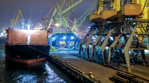 De tijd dringt. China. Vrachtvervoer met bulkschip afgemeerd op de pier. Grote vrachtterminal bij de zeehaven. Granen bulkvervoer van het wegvervoer naar het schip 's nachts. Vervoer van landbouwproducten. - Video
