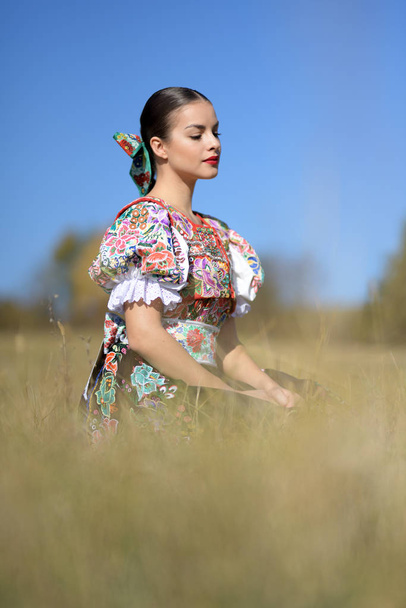 Young beautiful slovak folklore woman in traditional costume - Foto, Imagen