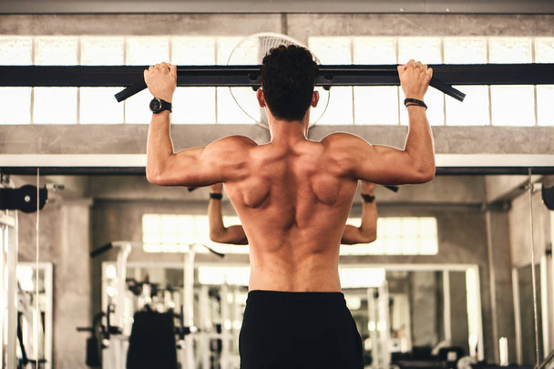 young caucasian strong man having workout using horizontal bar f - Фото, изображение