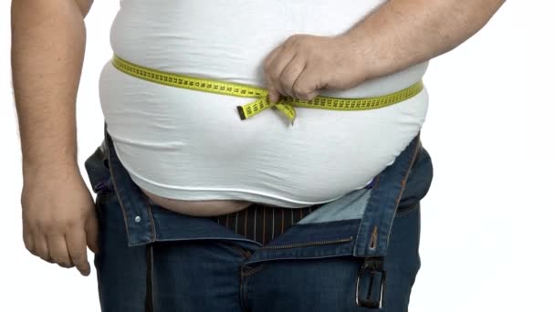 太った男は測定テープで彼の体をチェックします. - 映像、動画
