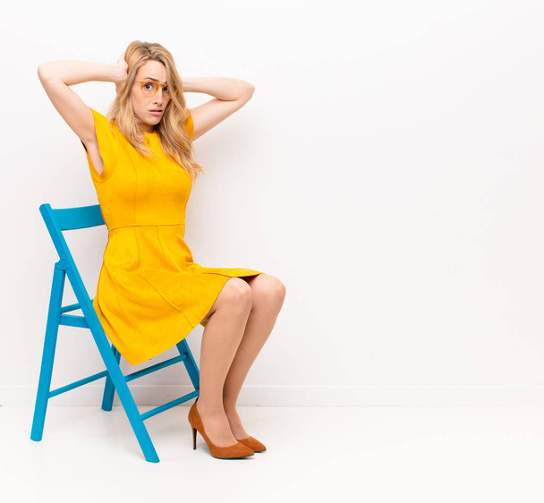 young pretty blonde woman feeling frustrated and annoyed, sick and tired of failure, fed-up with dull, boring tasks against flat color wall - Foto, immagini