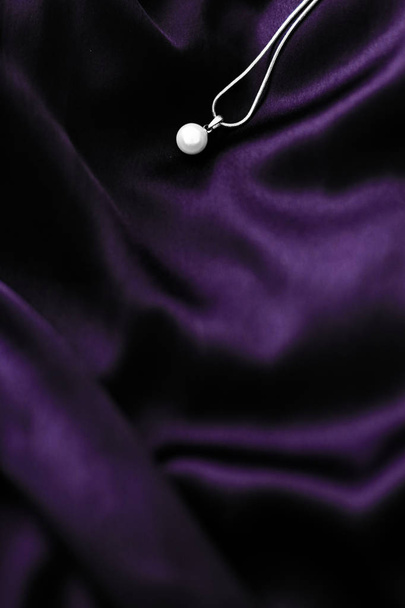 Luxury white gold pearl necklace on dark violet silk background, - Photo, Image