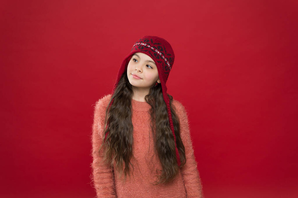 Dreamy mood. Little kid wear knitted hat. Stay warm. Little girl winter fashion accessory. Small adorable child long hair wear hat burgundy background. Cute model enjoy winter style. Winter outfit - Foto, Bild