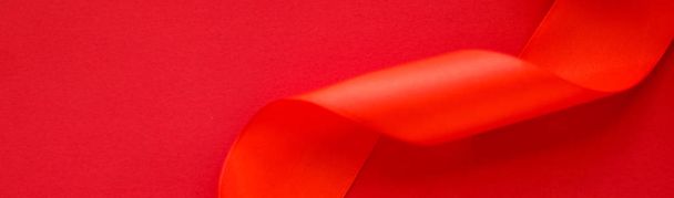 Абстрактная кудрявая шелковая лента на красном фоне, эксклюзивная роскошь б
 - Фото, изображение