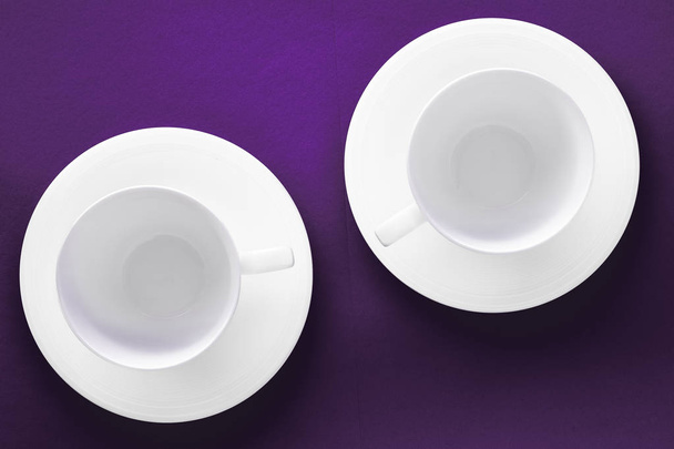 Set stoviglie bianche, tazza vuota su fondo piatto viola
 - Foto, immagini