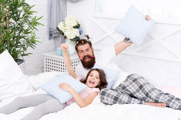 funny pajama party. small girl with bearded father in bed. weekend at home. Happy fatherhood. father and daughter having fun. family bonding time. i love my daddy. happy morning together - Fotó, kép