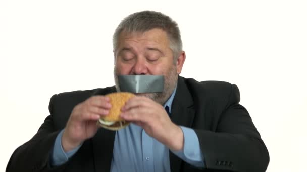 Businessman with taped mouth can not eating junk food. - Footage, Video