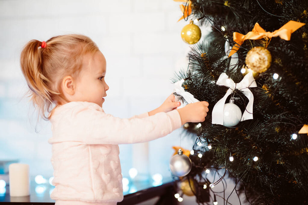 Imádnivaló kis csecsemő díszítő karácsonyfa otthon - Fotó, kép