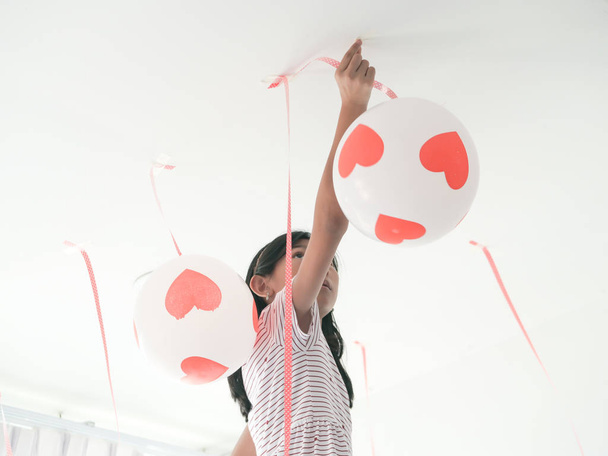 fondo borroso chica asiática colgando globo en el techo, prepari
 - Foto, imagen