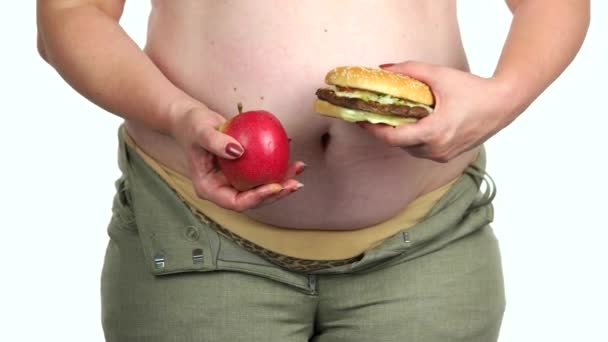 Tlustá žena drží zdravé a nezdravé jídlo. - Záběry, video