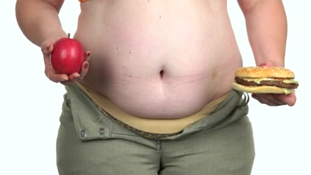 脂肪の女性は、アップルとバーガーの間で選択. - 映像、動画