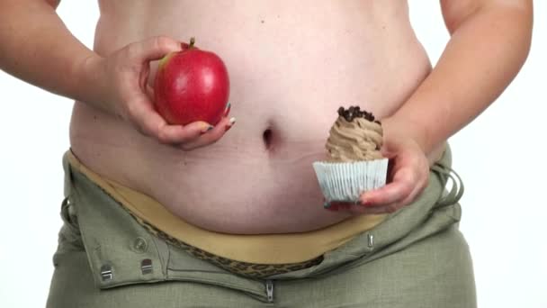 Tlustá žena drží dort a jablko. - Záběry, video