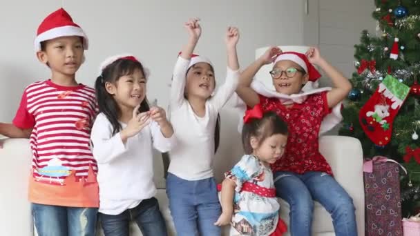 Маленькі діти в різдвяній шапці грають радісно у вітальні на Різдво
. - Кадри, відео