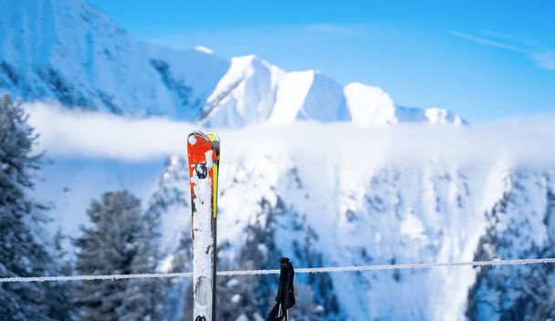 Skis, bâtons de ski sur fond de montagnes dans une station enneigée
 - Photo, image